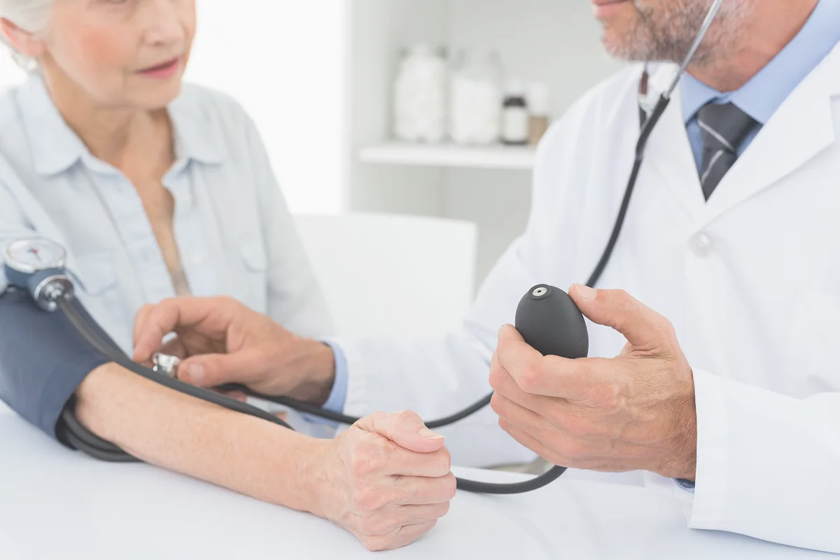 Médico tomando la presión a un paciente